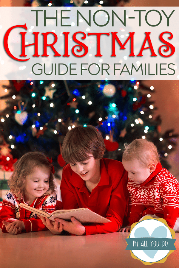 siblings reading a book in front of Christmas tree with overlay "The Non-Toy Christmas Guide for Families"